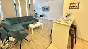 A modern living room with a sectional sofa, a small coffee table, and a dining area with a bar.