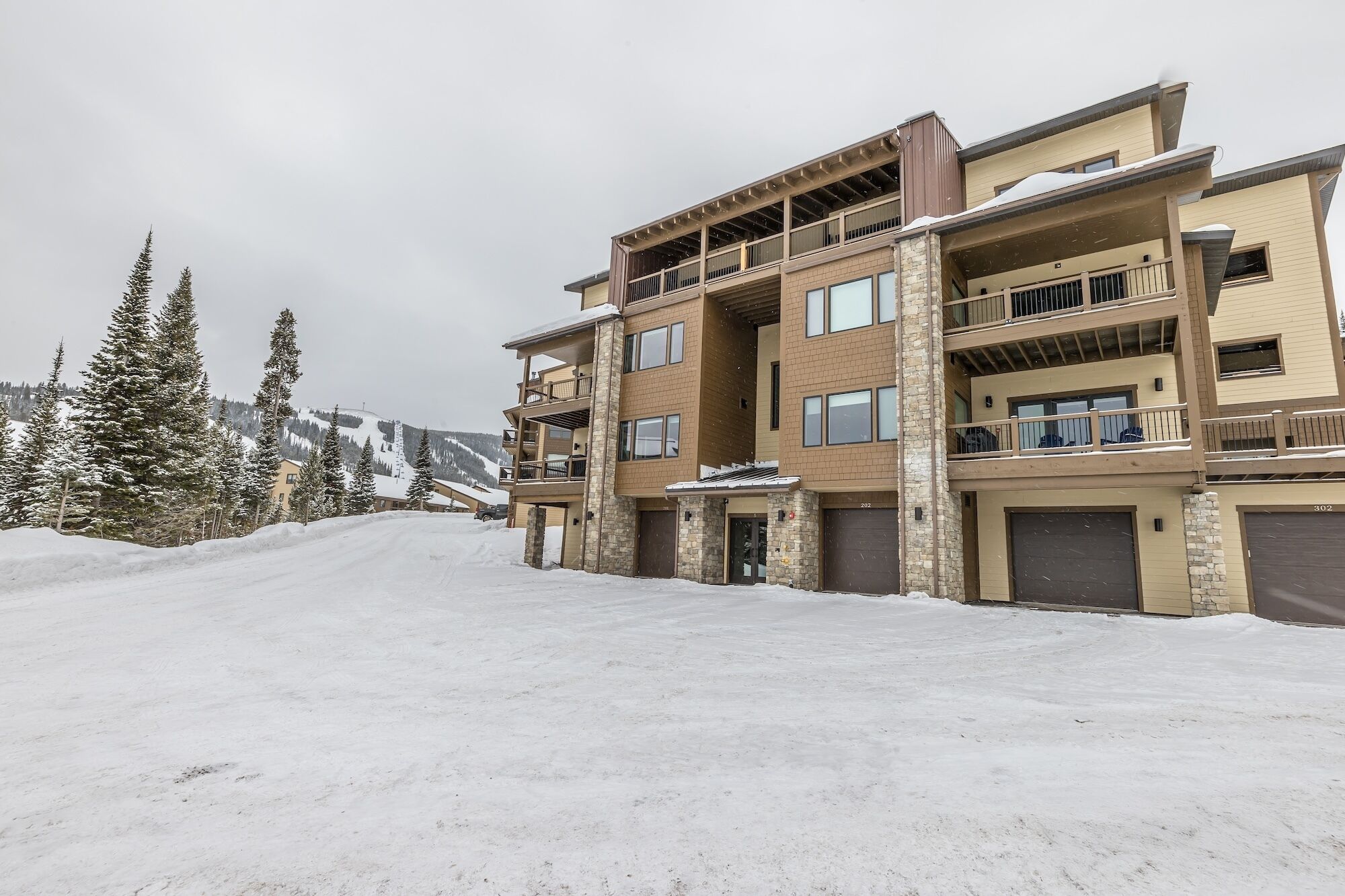 A multi-story hotel with a ski slope in the background.