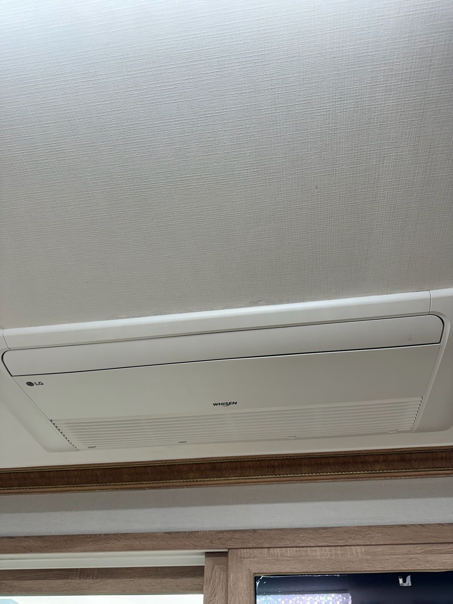 A ceiling with a white air conditioning unit labeled 'LG WHISEN'.
