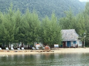 A beachside view with a thatched-roof hut, lounge chairs, and a sign reading "Passage Bay". - Emerald Lagoon Retreat Phu Quoc (Phu Quoc)