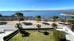 A coastal property with a paved driveway, manicured lawn, and palm trees. - Apartment Luky 6 (Dramalj)