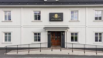 Un edificio blanco con un letrero negro que dice 'HOTEL GAMLA STADEN'.