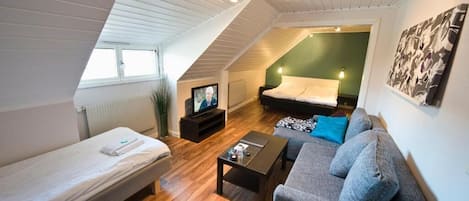 Familjerum | Minibar, skrivbord, arbetsyta för laptop och mörkläggningsgardiner