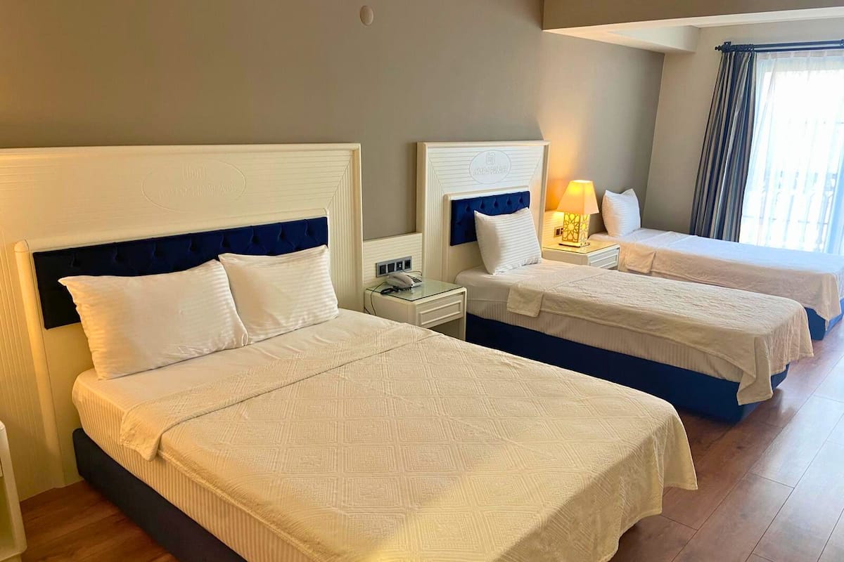 Habitación cuádruple familiar | Caja de seguridad en la habitación, escritorio y cortinas blackout