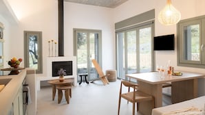 Eine moderne Küche mit Kamin, Essbereich und großen Fenstern.