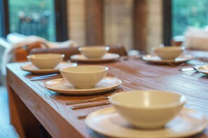 Una mesa de comedor con cuencos y palillos, que sugiere un ambiente de restaurante.
