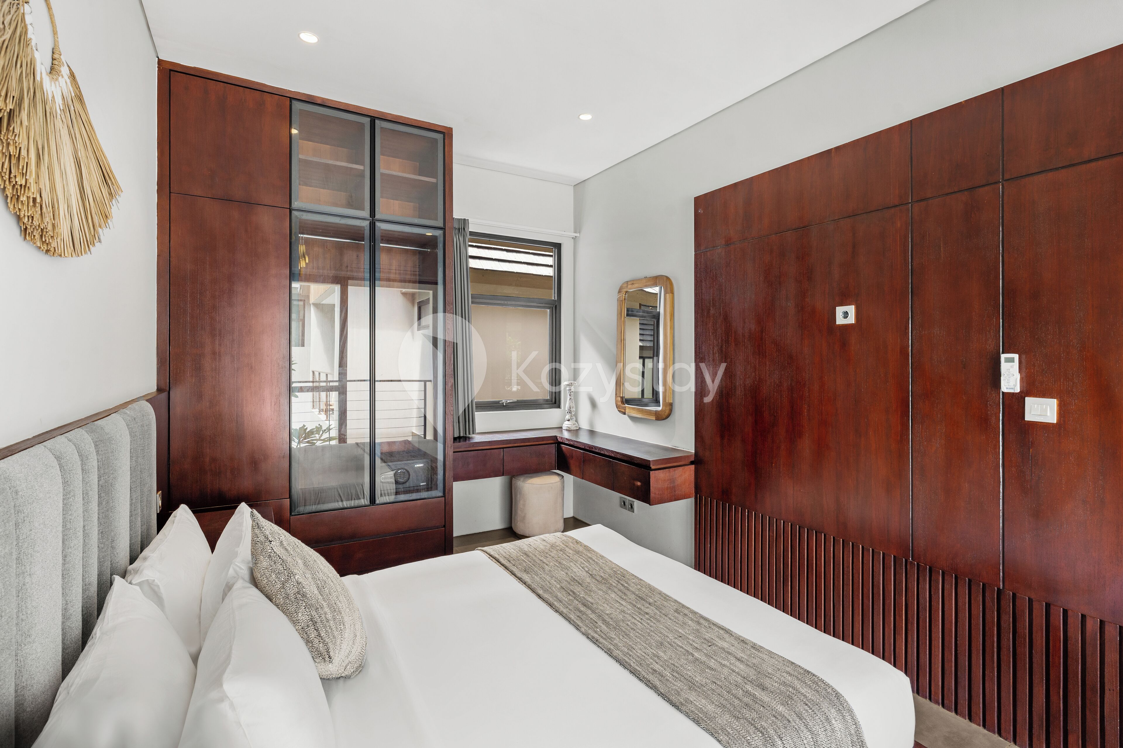 Un dormitorio con cama, armario de madera, espejo y ventana.