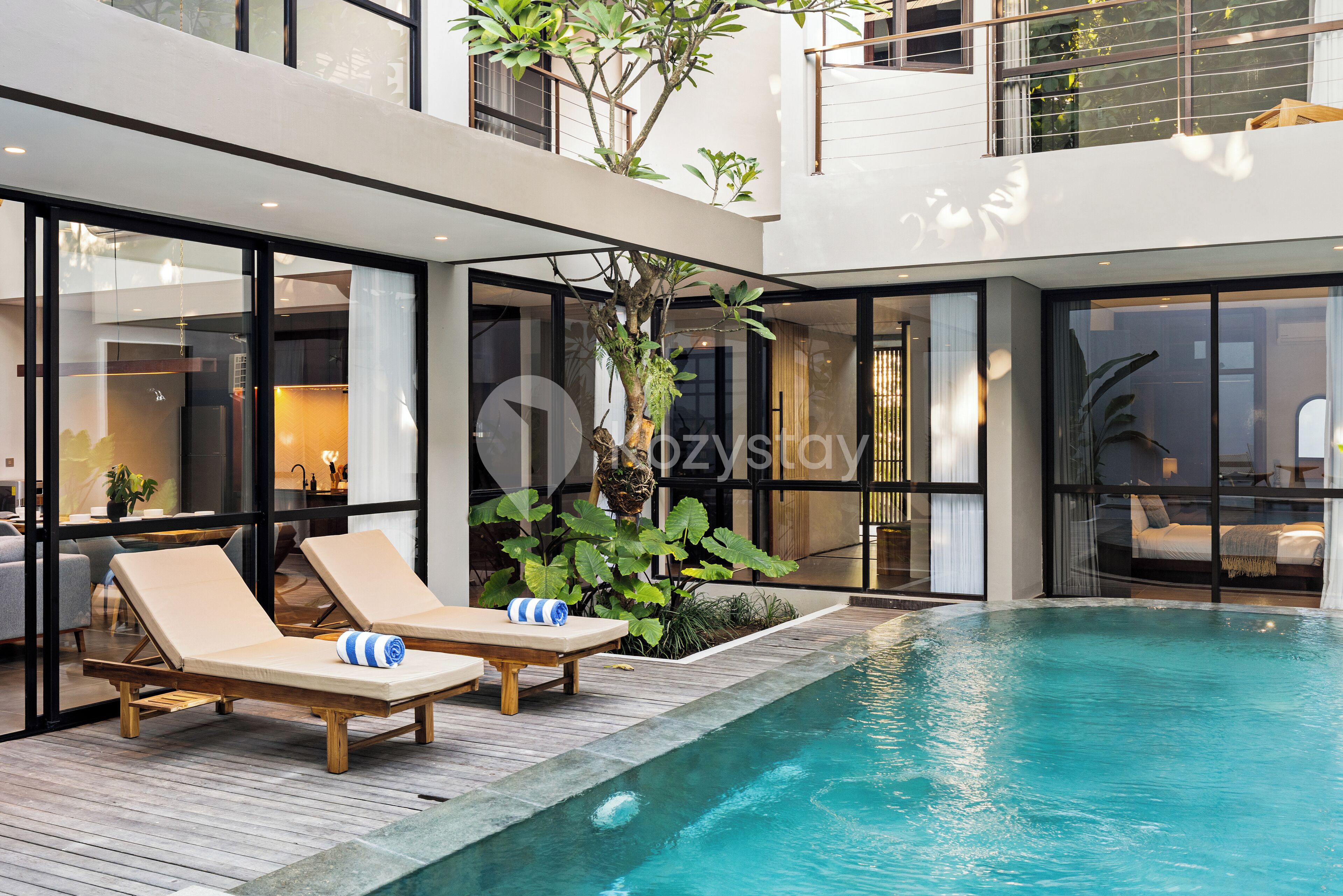 A modern outdoor pool area with lounge chairs and a wooden deck.