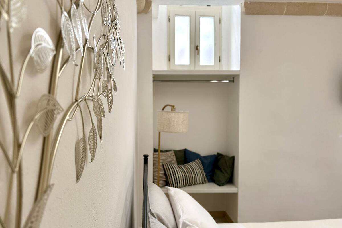 Une chambre à coucher comprenant un lit, une table de chevet, une lampe et une armoire avec un miroir.