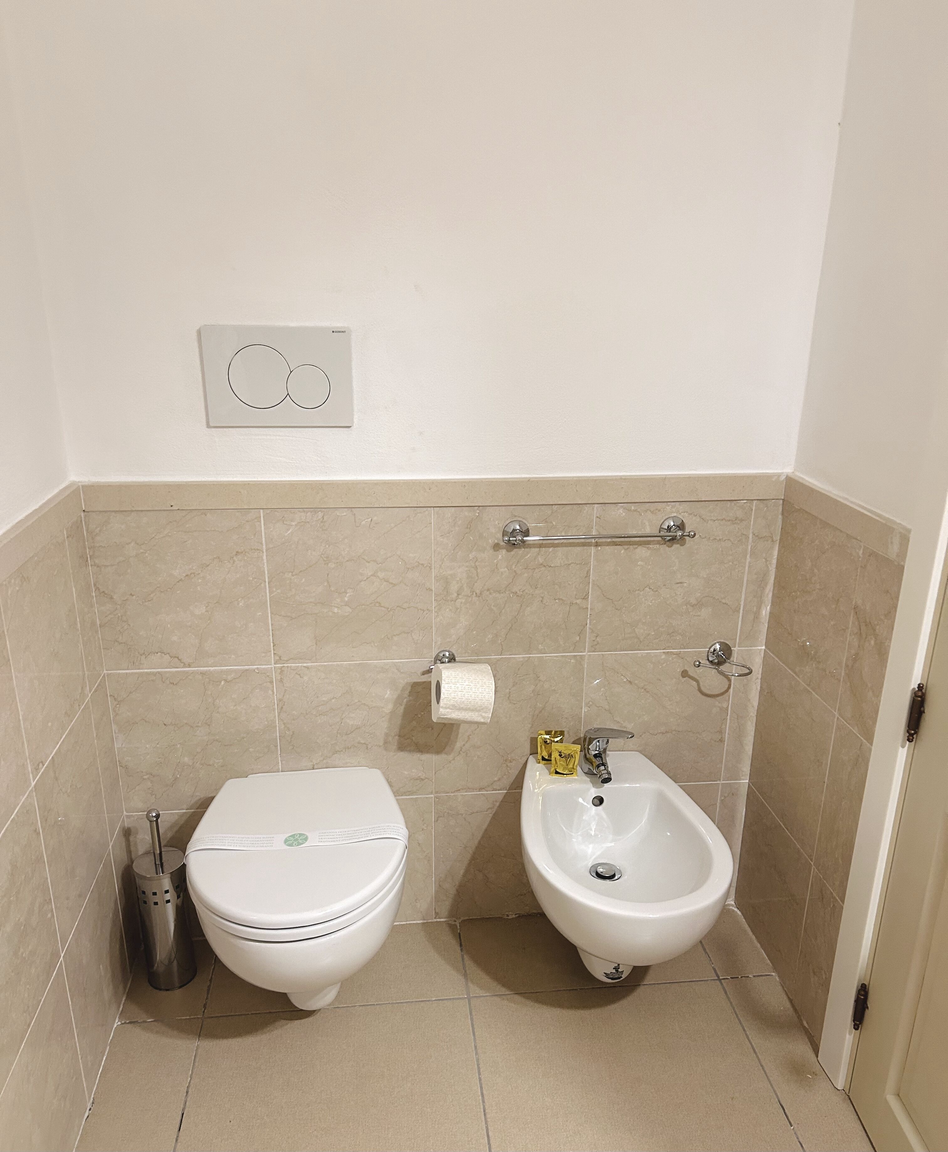 A bathroom with a toilet, bidet, and sink.