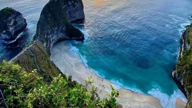 Paisaje costero con un atardecer, formaciones rocosas y aguas azules cristalinas.