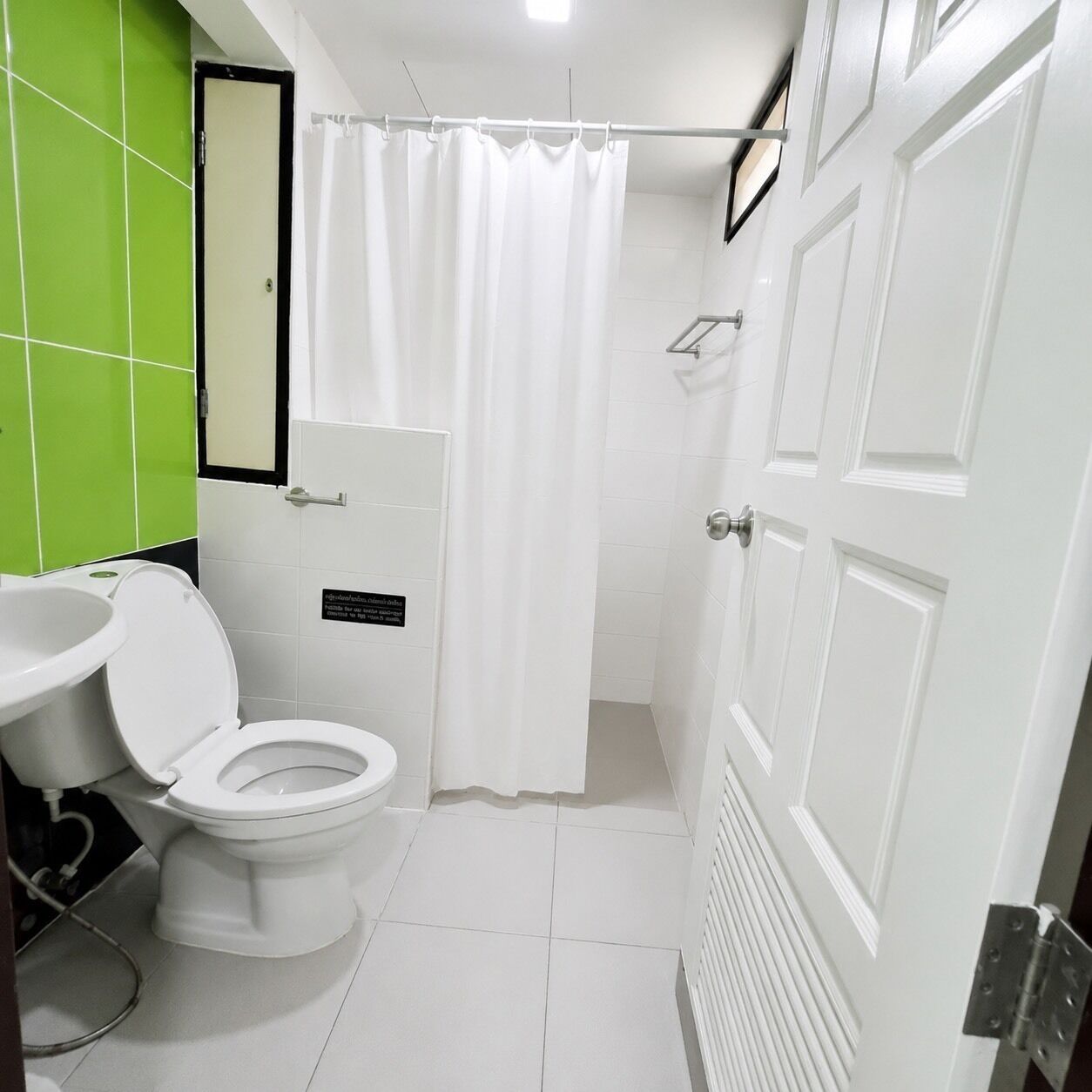 A bathroom with a toilet, sink, and shower curtain.