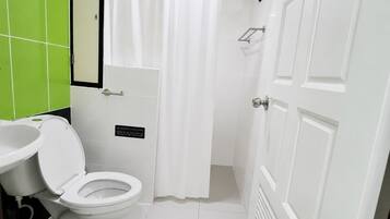 A bathroom with a toilet, sink, and shower curtain.