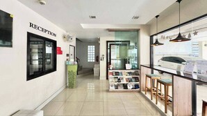 Zona de recepción con una vitrina de libros y un mostrador de recepción.
