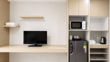 A modern kitchen with a built-in TV, a refrigerator, and a microwave.