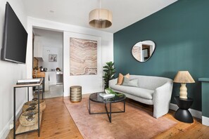 Relax in this stylish living room with a sofa, coffee table, floor lamp, and large mirror.