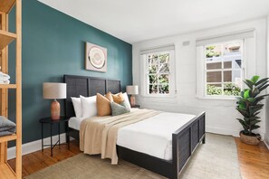 Relax in a stylish bedroom with a large bed, bedside tables, and a window offering a view of the outdoors.