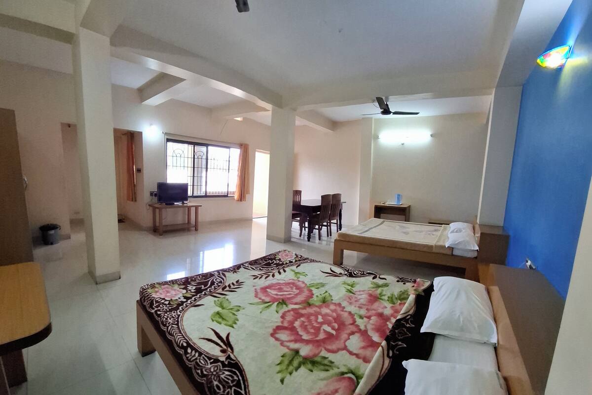Una camera d'albergo con un letto grande, una scrivania, una sedia e un'area pranzo con tavolo e sedie.