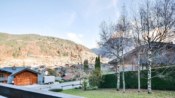 Un barrio residencial con casas, una calle y una montaña al fondo.