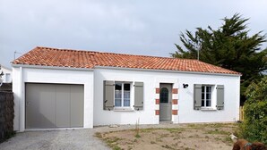 A two-story house with a tiled roof, a front door, and a garage. - Vendée House 3 BR, Pet-Friendly, Near Beach (Notre-Dame-de-Monts)