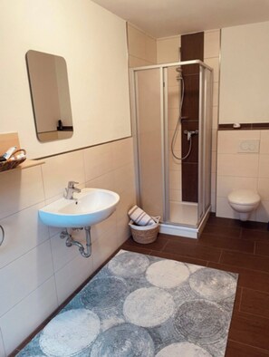 Een douche, handdoeken, toiletpapier