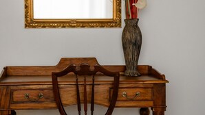A wooden desk with drawers and a chair in front.