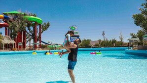 A water park with a large pool, water slides, and inflatable rafts.
