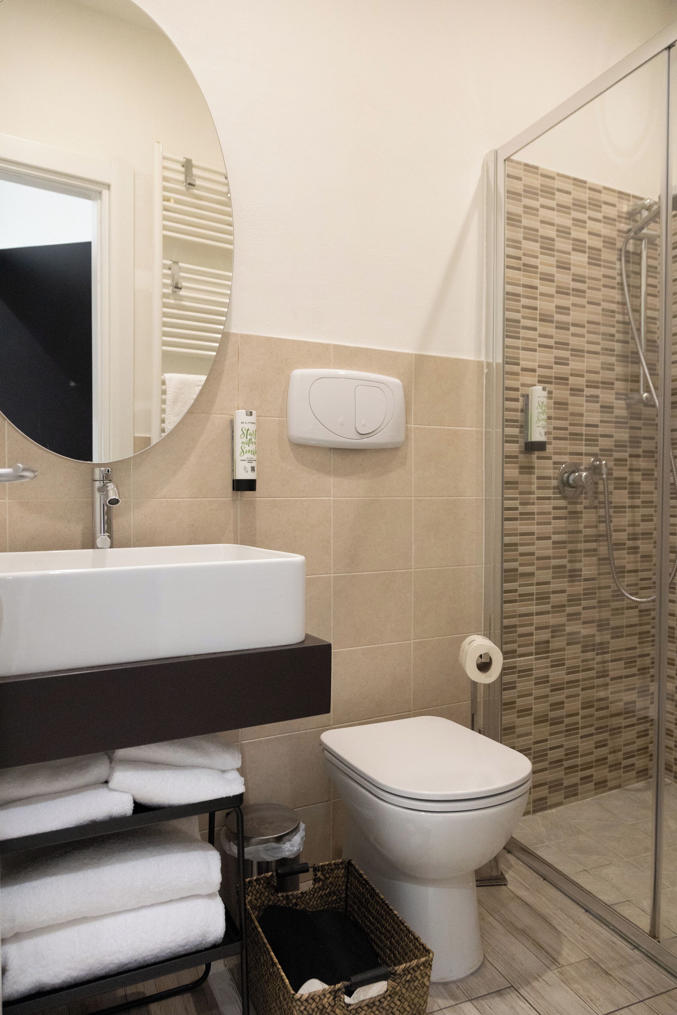 A bathroom with a sink, mirror, toilet, and shower.