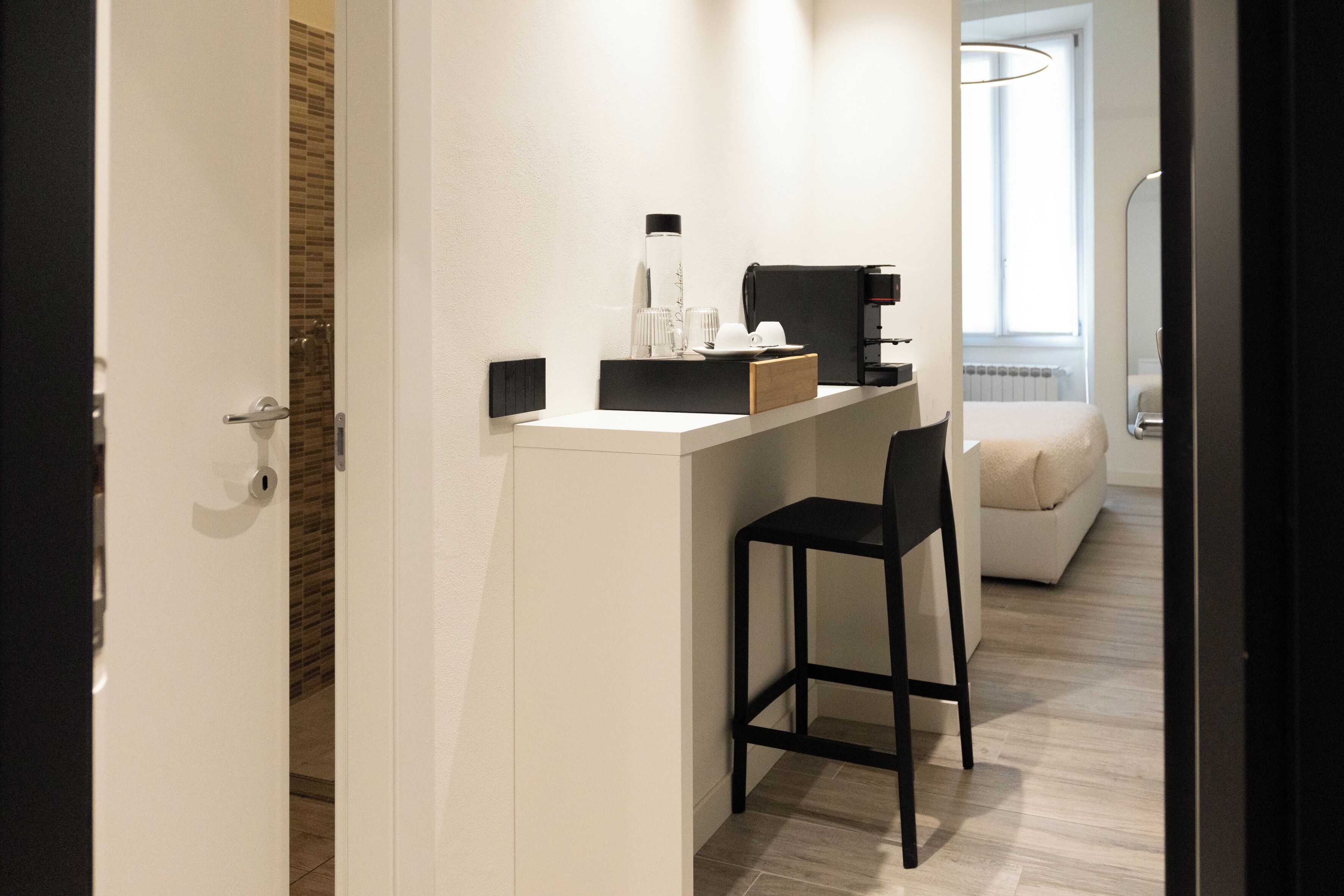 Ein kompaktes Hotelzimmer mit Küchenzeile, einer kleinen Sitzecke und einem Bett.