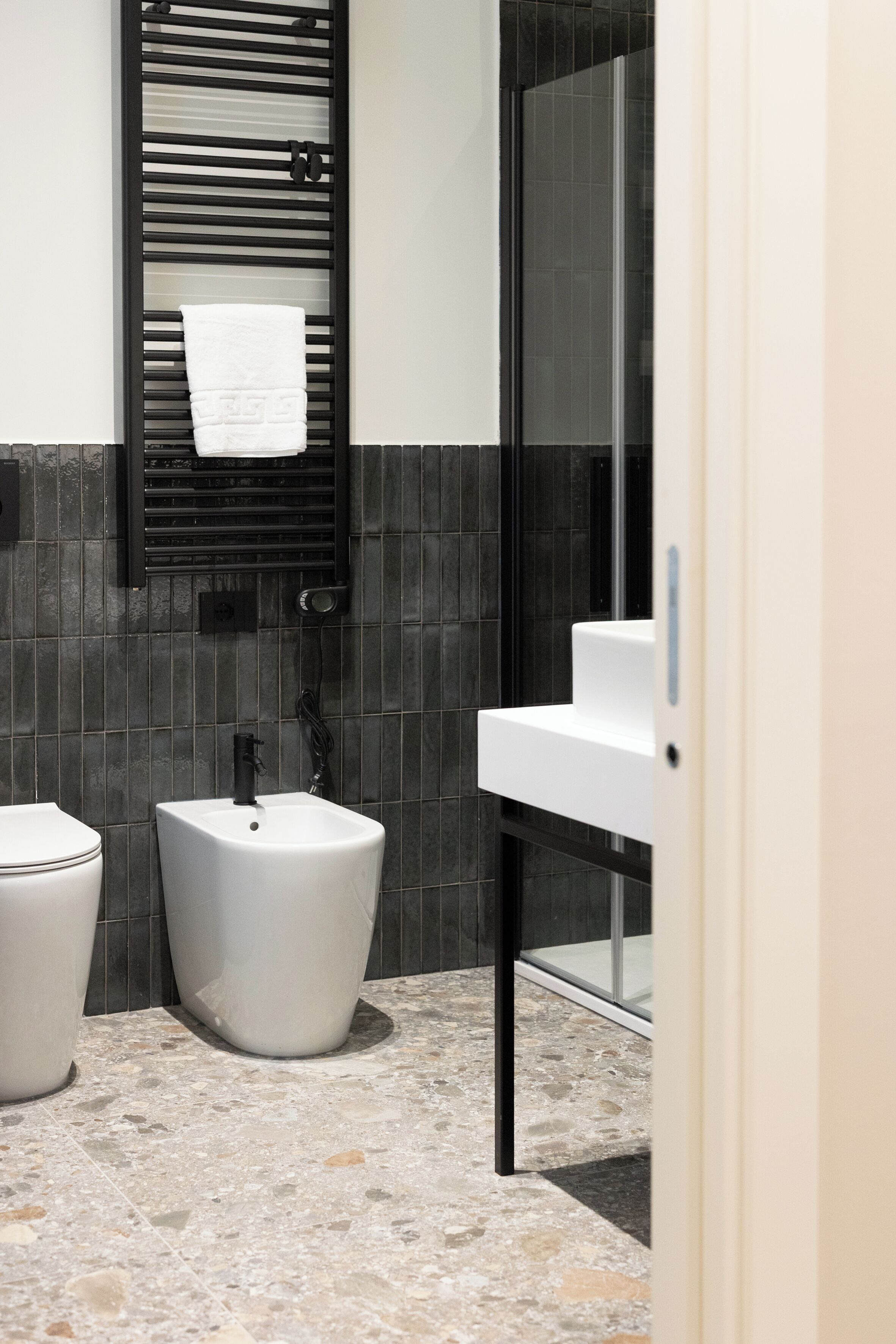 Et moderne badeværelse med toilet, bidet og vask.