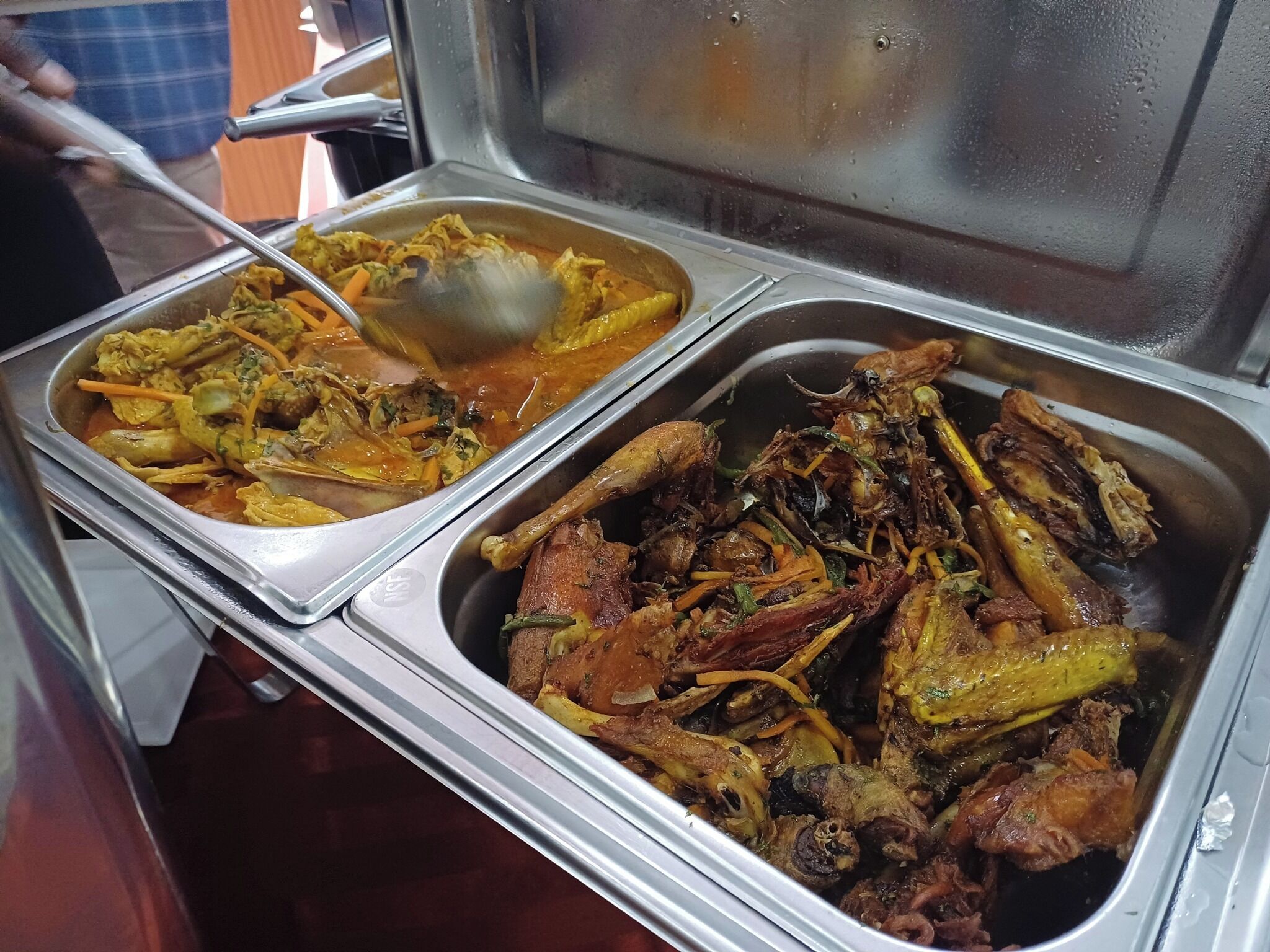 A buffet with various dishes including a curry and roasted meats.