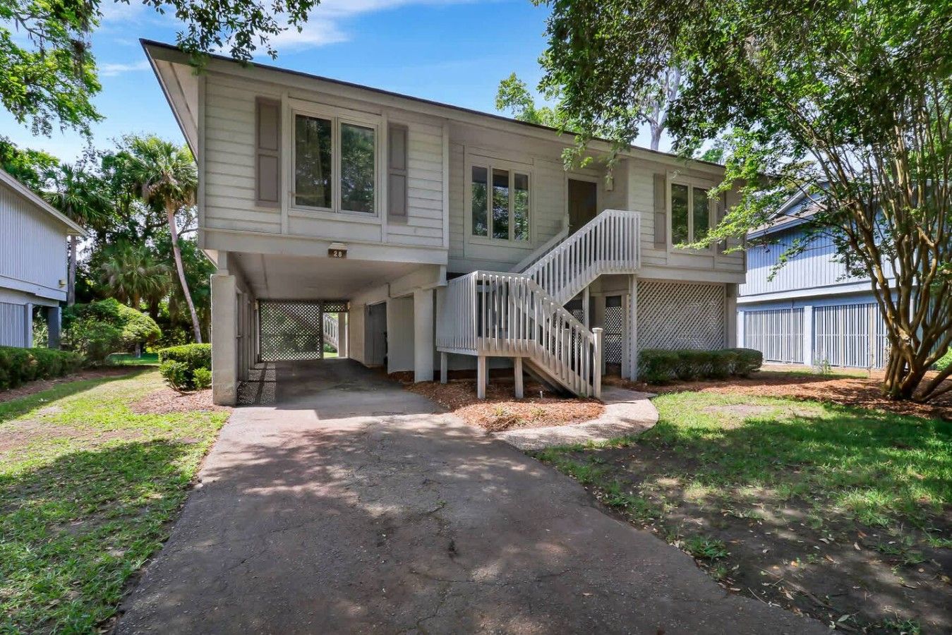 A two-story house with a covered porch and a staircase leading to the upper level.