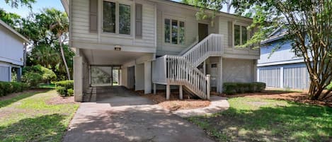 A two-story house with a covered porch and a staircase leading to the upper level.