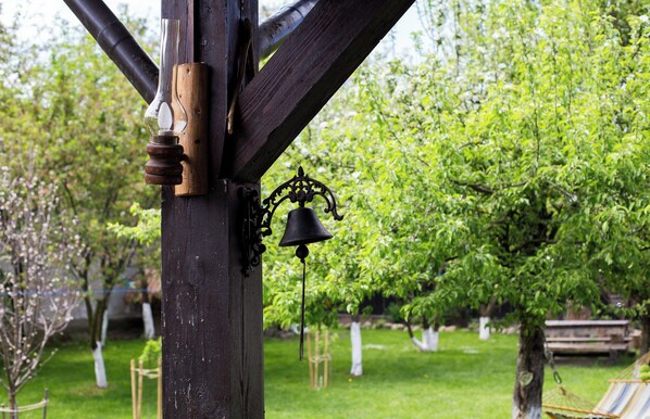 A wooden structure with a bell and a glass object attached to it.