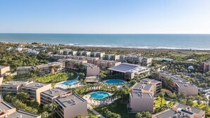 Ein Resort mit mehreren Gebäuden, einem großen Pool und Blick auf den Ozean.
