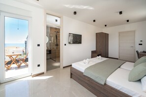 A modern bedroom with a bed, a wooden wardrobe, and a bathroom visible through an open door. - The old man and the sea Inn (Novalja)