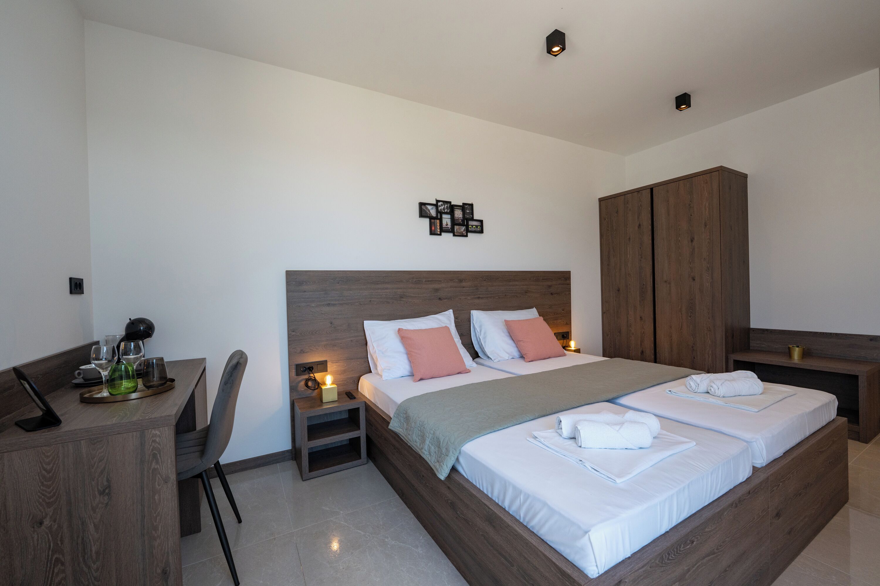 Ein modernes Schlafzimmer mit einem großen Bett, Nachttischen, einem Schreibtisch und einem Kleiderschrank.