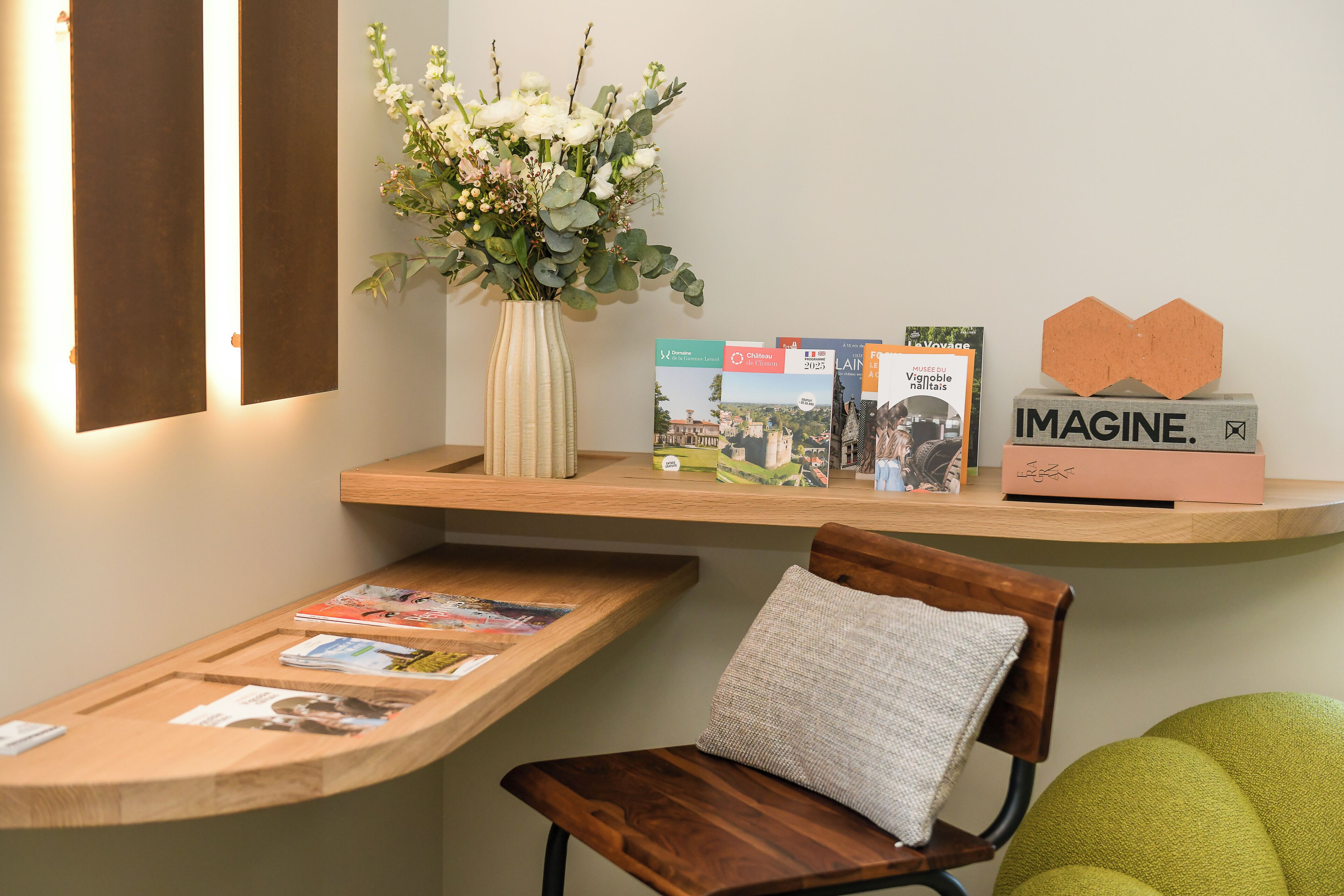 Una recepción con un florero, revistas y un tablón de anuncios.