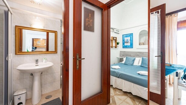 A bathroom with a sink, mirror, and toilet.
