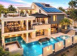 A modern two-story house with a swimming pool, outdoor seating, and solar panels. - An Elevated Luxury Retreat for Unforgettable Gatherings (Humacao)