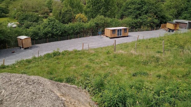 A rural landscape with a gravel path leading to a wooden cabin and a shed. - Llandovery - Cabin - Sleeps 2 - Parking - Garden (Llandovery)