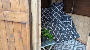 A wooden room with a bed, pillows, a small table, and a potted plant. - Llandovery - Cabin - Sleeps 2 - Parking - Garden (Llandovery)
