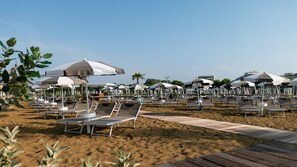 A beach with rows of sun loungers and umbrellas, a wooden walkway, and palm trees.