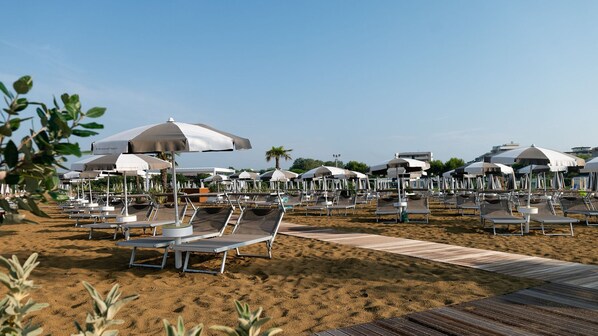 A beach with rows of sun loungers and umbrellas, a wooden walkway, and palm trees.