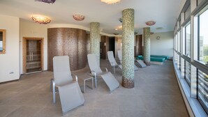 Un espace d’attente moderne, avec une rangée de chaises, un comptoir d’accueil et une grande fenêtre donnant sur un paysage agréable.