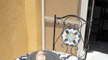 A table with a croissant, a cup, and a saucer.