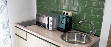 A kitchen with a toaster, a kettle, and a sink.