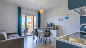 A modern kitchen with a built-in microwave, a sink, and a dining area with a table and chairs.
