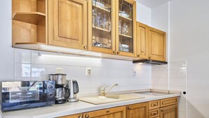 A kitchen with wooden cabinets, a stainless steel coffee maker, and a microwave. - Beautiful apartment for 4 people with WIFI and TV (Jilemnice)