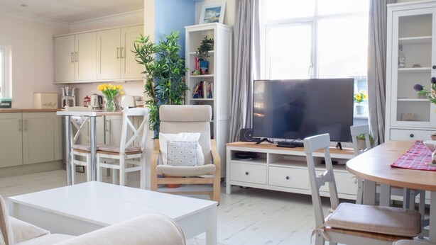 A modern living room with a TV, seating, and a kitchen area. - Stunning private villa for 6 people with WIFI and TV (Isle Of Skye)